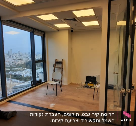 אדם עובד על רצפת עץ ליד חלון גדול